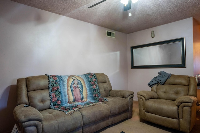 carpeted cinema room featuring baseboard heating, ceiling fan, and a textured ceiling