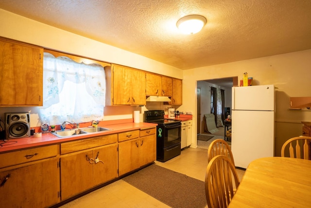 kitchen with white fridge, black electric range oven, sink, and a textured ceiling