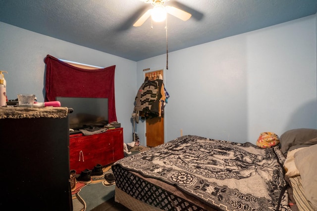 carpeted bedroom with ceiling fan and a textured ceiling