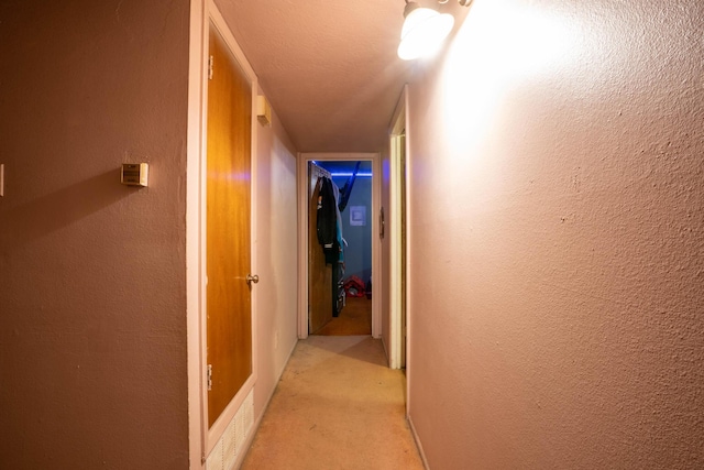 hall featuring light colored carpet