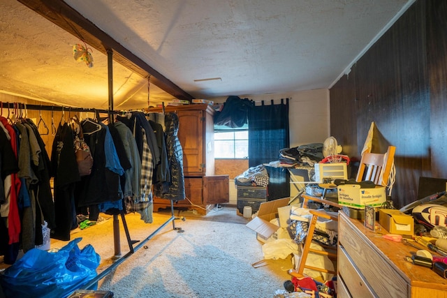 interior space featuring beam ceiling, carpet floors, and wood walls