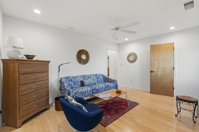 living room featuring light hardwood / wood-style floors and ceiling fan