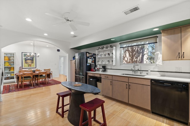 kitchen with sink, ceiling fan with notable chandelier, light wood-type flooring, and black appliances