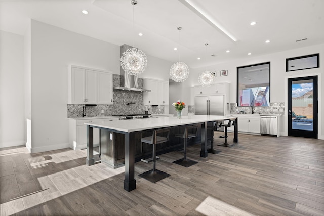 kitchen featuring hanging light fixtures, a large island, a breakfast bar area, and white cabinets