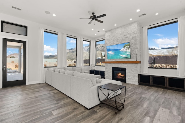 living room featuring hardwood / wood-style floors, a fireplace, and ceiling fan