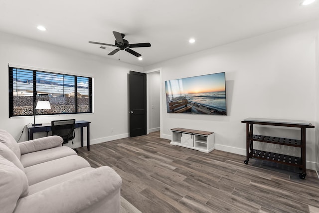 living room with ceiling fan and dark hardwood / wood-style flooring