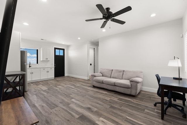 living room with wood-type flooring, sink, and ceiling fan