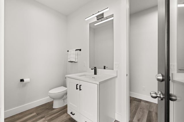 bathroom with wood-type flooring, toilet, and vanity