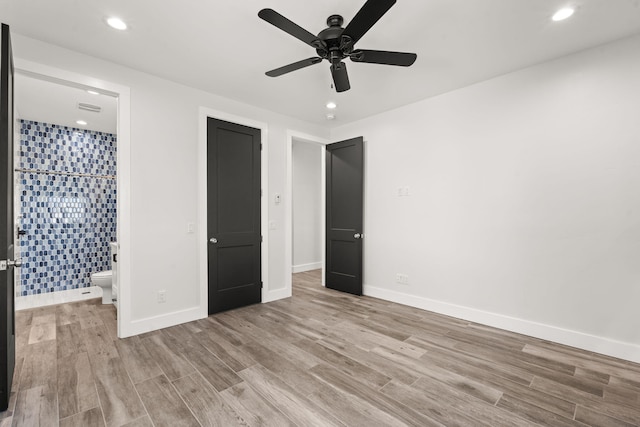 unfurnished bedroom featuring ensuite bathroom, ceiling fan, and light wood-type flooring