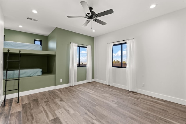 unfurnished bedroom with ceiling fan and light hardwood / wood-style flooring