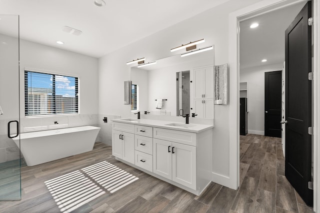 bathroom featuring hardwood / wood-style flooring, vanity, separate shower and tub, and tile walls