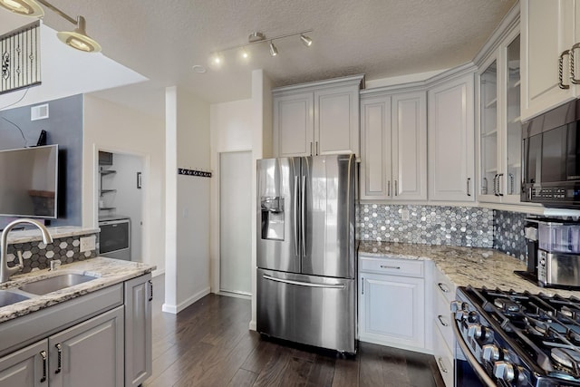 kitchen featuring sink, light stone counters, decorative backsplash, and appliances with stainless steel finishes