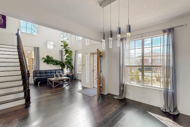 dining space featuring dark wood-type flooring, plenty of natural light, and a textured ceiling