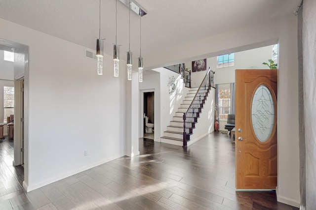 foyer with a textured ceiling and dark hardwood / wood-style flooring