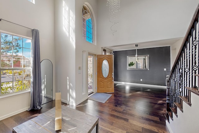 foyer entrance featuring plenty of natural light, dark wood-type flooring, and a high ceiling