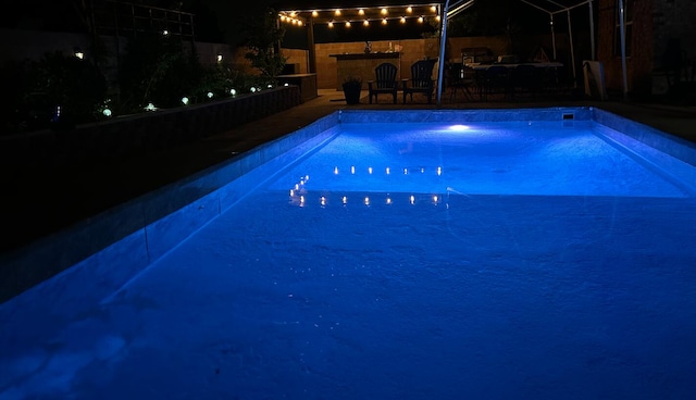 view of pool at twilight