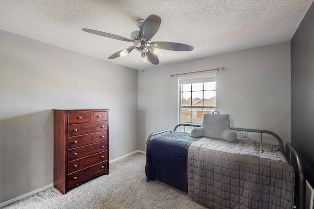 bedroom with ceiling fan, a textured ceiling, and light carpet