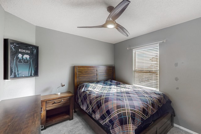 carpeted bedroom with ceiling fan and a textured ceiling