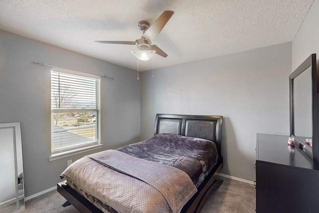 carpeted bedroom with ceiling fan and a textured ceiling