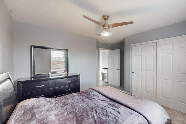 bedroom with carpet, a textured ceiling, a closet, and ceiling fan