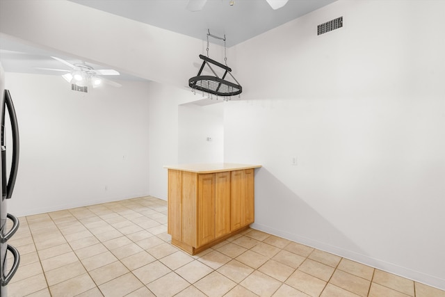 kitchen featuring ceiling fan, light brown cabinets, and light tile patterned flooring