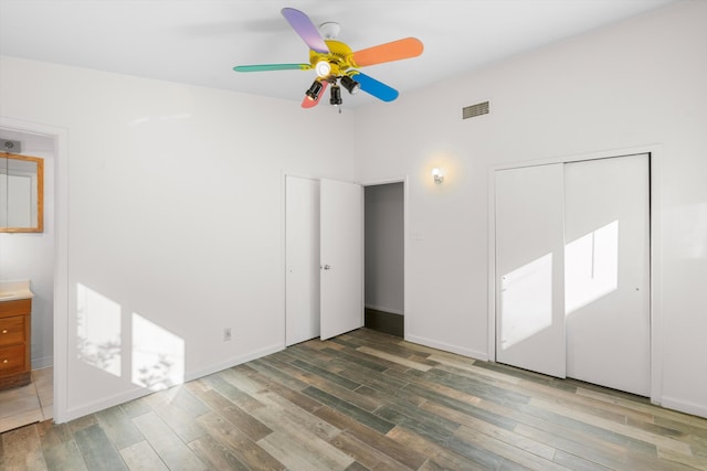 unfurnished bedroom with ceiling fan, dark hardwood / wood-style flooring, and a closet