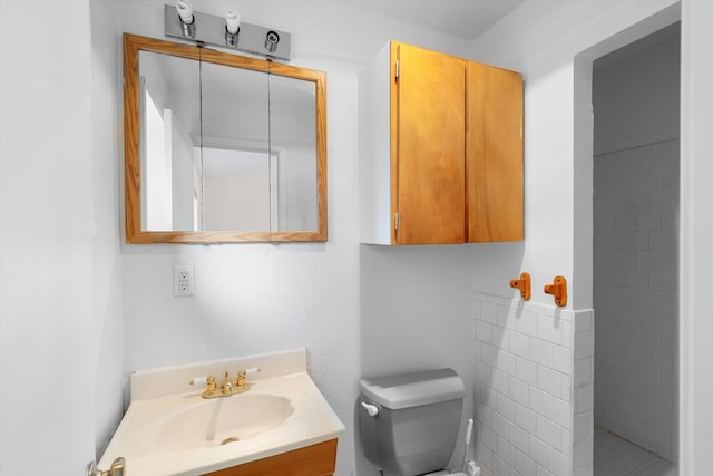 bathroom featuring toilet, vanity, and walk in shower