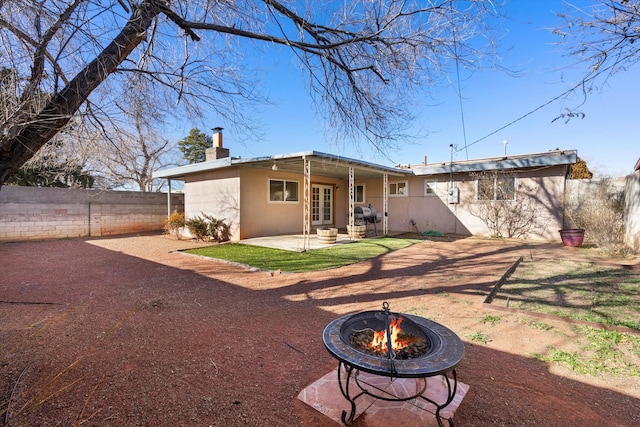 back of house featuring an outdoor fire pit and a patio