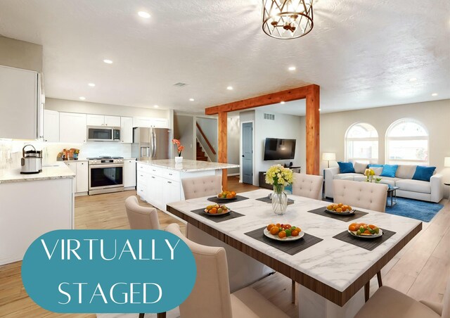 dining space with a notable chandelier and light hardwood / wood-style flooring