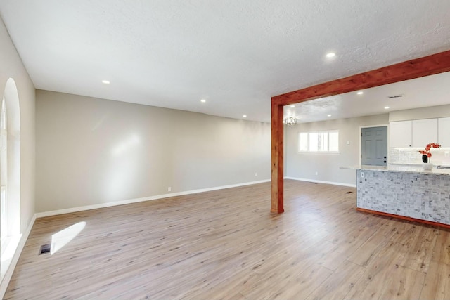 living room featuring light wood-type flooring and a textured ceiling