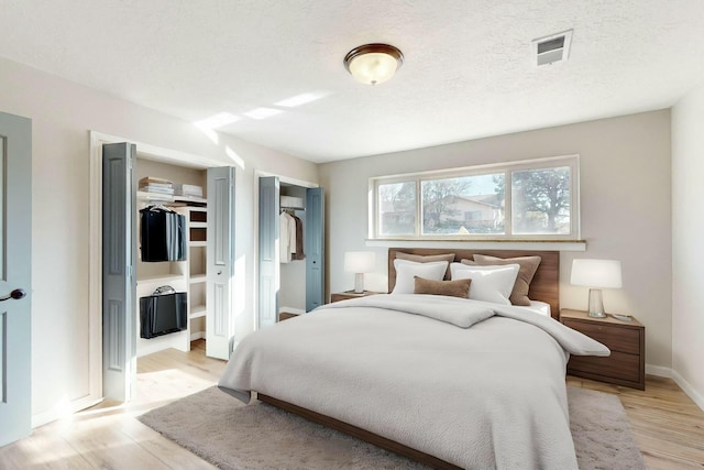 bedroom featuring light hardwood / wood-style flooring and a textured ceiling