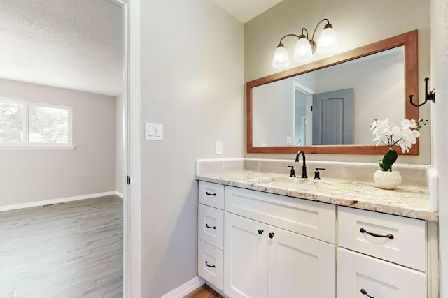 bathroom featuring hardwood / wood-style flooring, a textured ceiling, and vanity