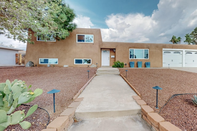 pueblo revival-style home featuring a garage