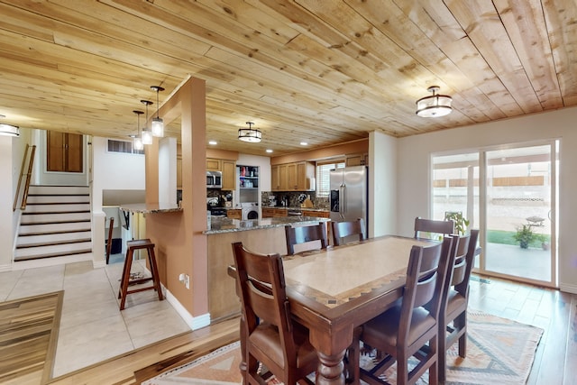 dining space featuring washer / clothes dryer, wooden ceiling, and light hardwood / wood-style floors