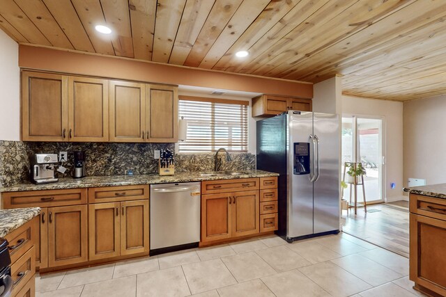 kitchen featuring sink, wood ceiling, appliances with stainless steel finishes, light stone countertops, and decorative backsplash