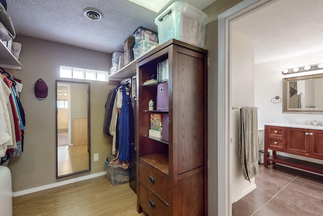 walk in closet featuring tile patterned flooring and sink