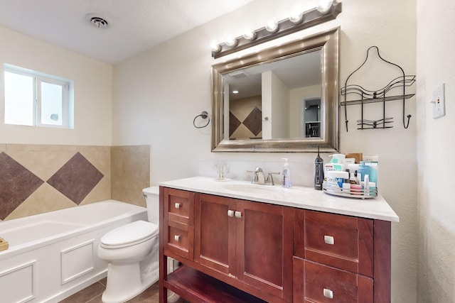 bathroom featuring a bathing tub, vanity, tile patterned floors, and toilet