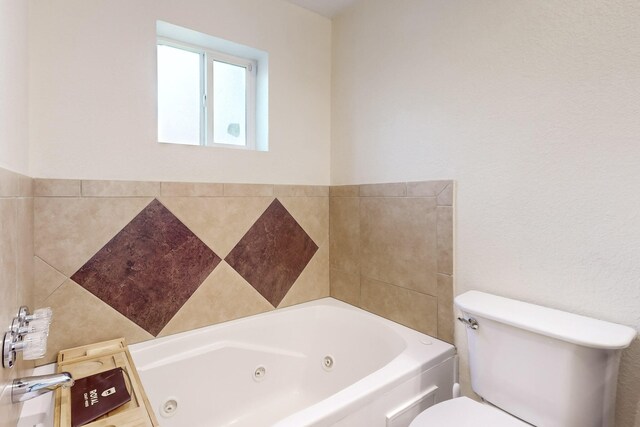 bathroom featuring a tub to relax in and toilet