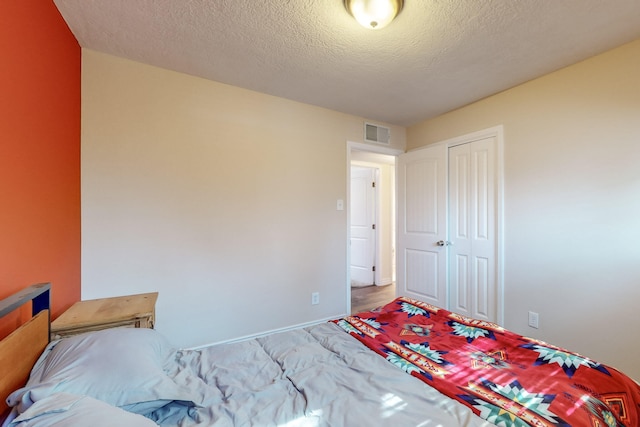 bedroom with a textured ceiling and a closet