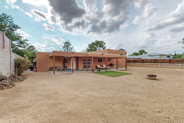 back of house with a patio area and a fire pit