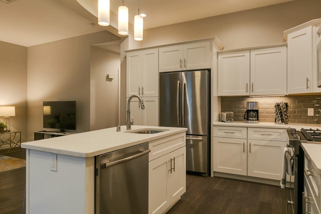 kitchen featuring appliances with stainless steel finishes, white cabinetry, sink, backsplash, and hanging light fixtures