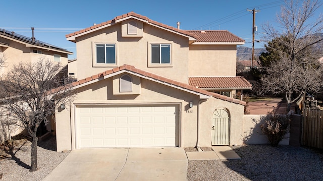 view of front facade featuring stucco siding, fence, a garage, driveway, and a tiled roof