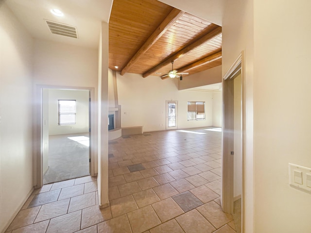 unfurnished living room featuring light tile patterned flooring, vaulted ceiling with beams, wooden ceiling, and ceiling fan