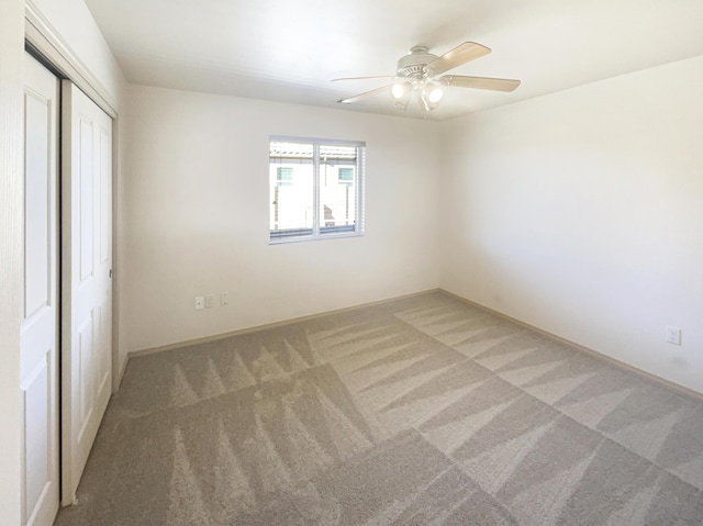 unfurnished bedroom with carpet floors, a closet, and ceiling fan