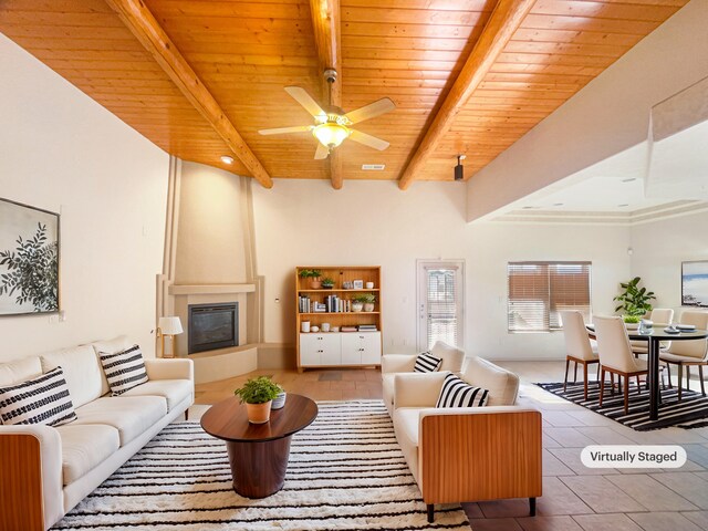 living room featuring ceiling fan, a fireplace, wooden ceiling, and beamed ceiling