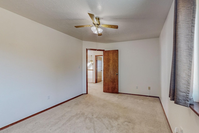 carpeted empty room featuring ceiling fan and a textured ceiling