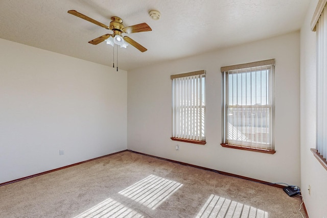 carpeted spare room with a textured ceiling and ceiling fan