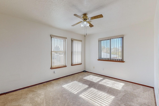 carpeted empty room with ceiling fan and a textured ceiling