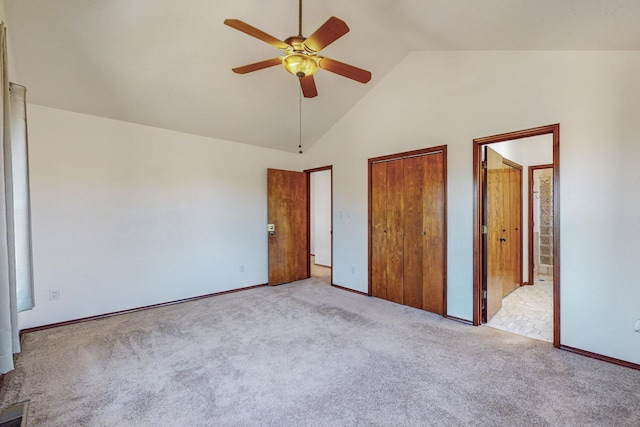 unfurnished bedroom with ceiling fan, light colored carpet, ensuite bathroom, and high vaulted ceiling