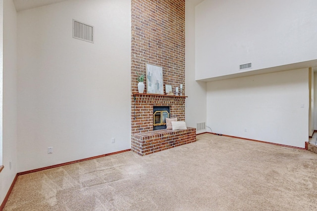 unfurnished living room with carpet floors and a towering ceiling